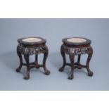 A pair of Chinese carved wooden stands with marble top, 19th/20th C.