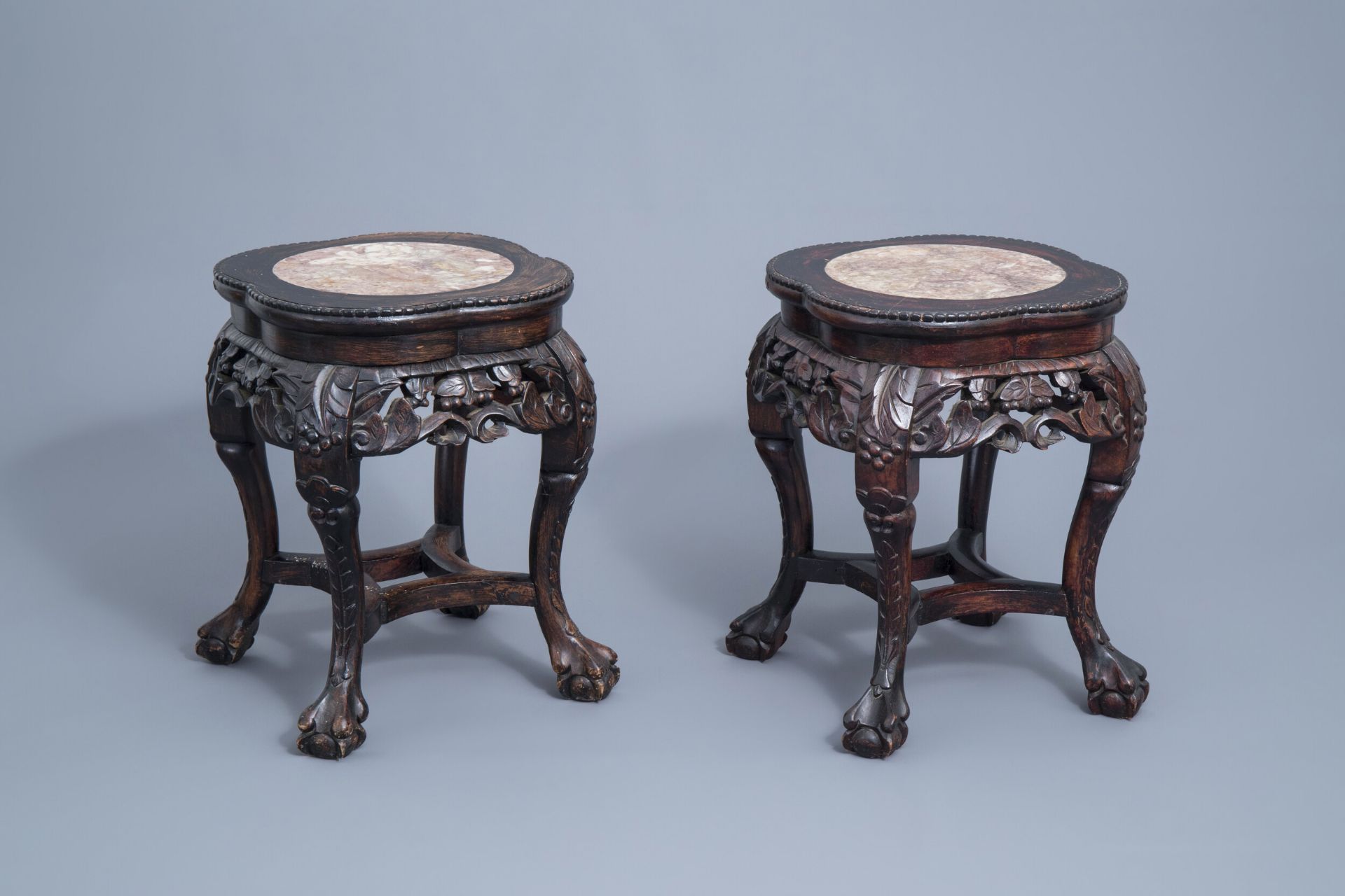 A pair of Chinese carved wooden stands with marble top, 19th/20th C.