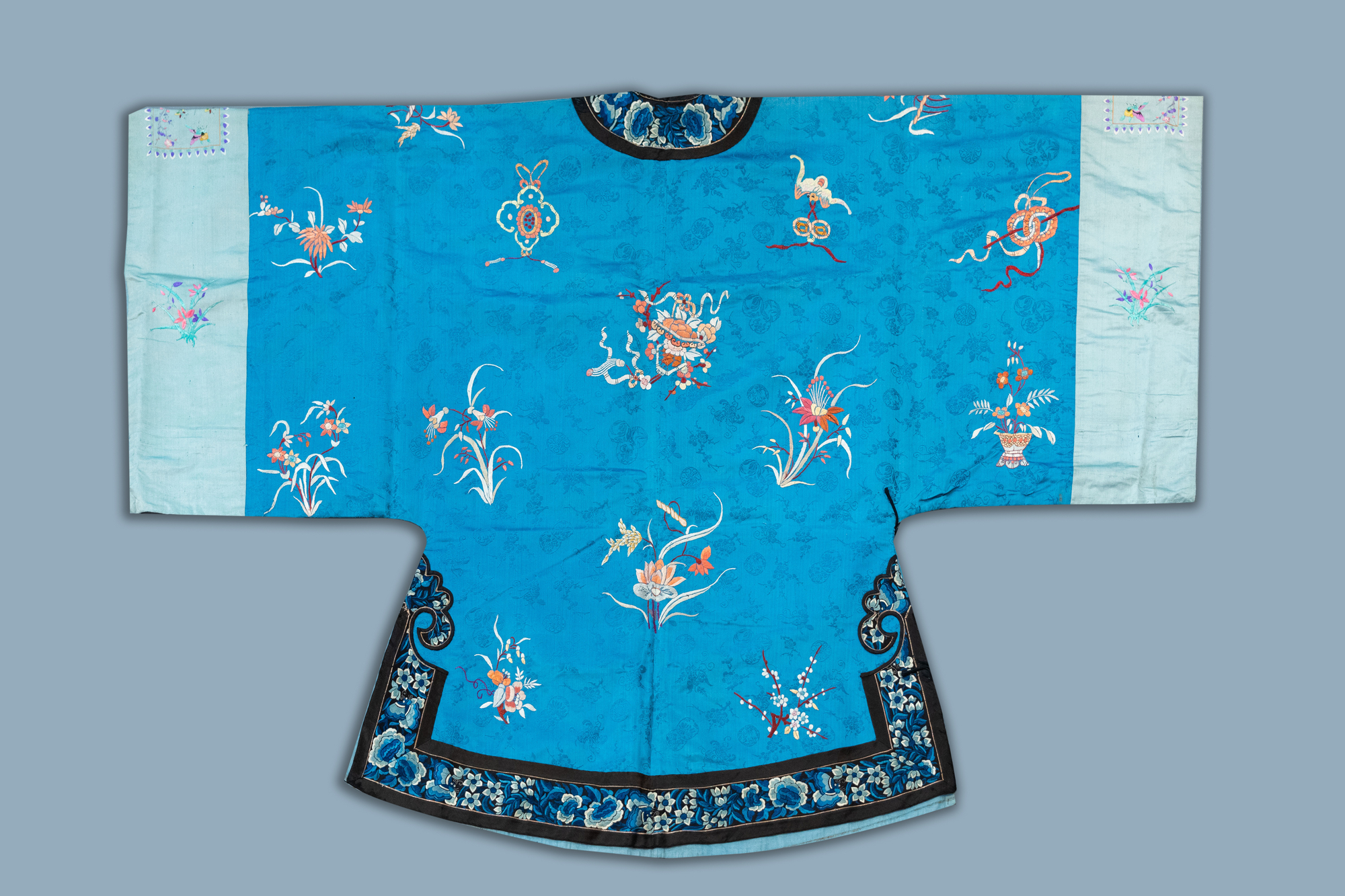 A Chinese blue ground embroidered silk women's robe with flowers and animals, 19th C. - Image 2 of 2