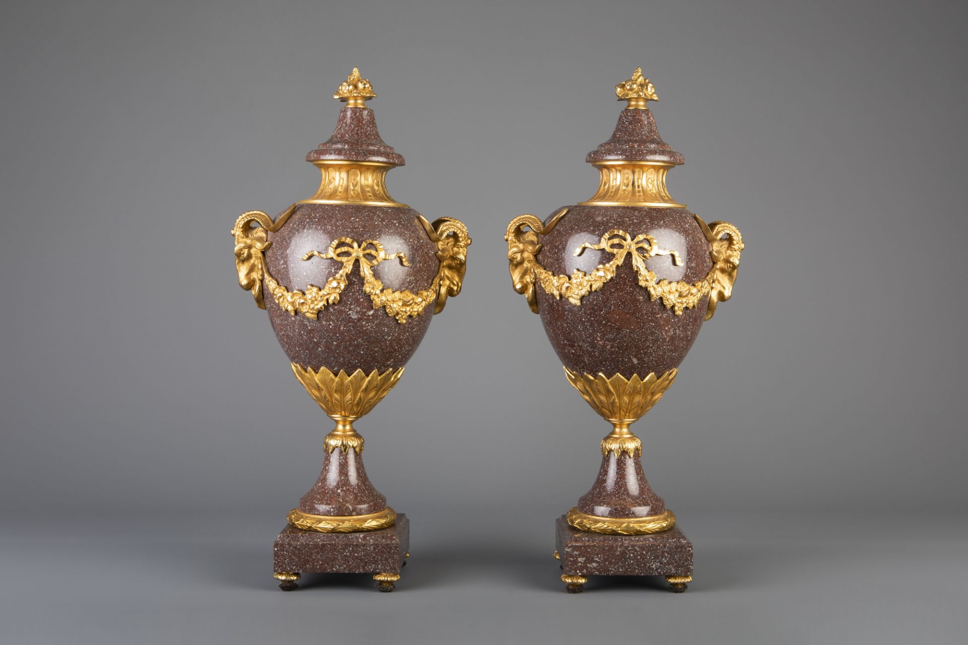 An imposing pair of gilt bronze mounted red porphyry cassolettes, 19th/20th C.