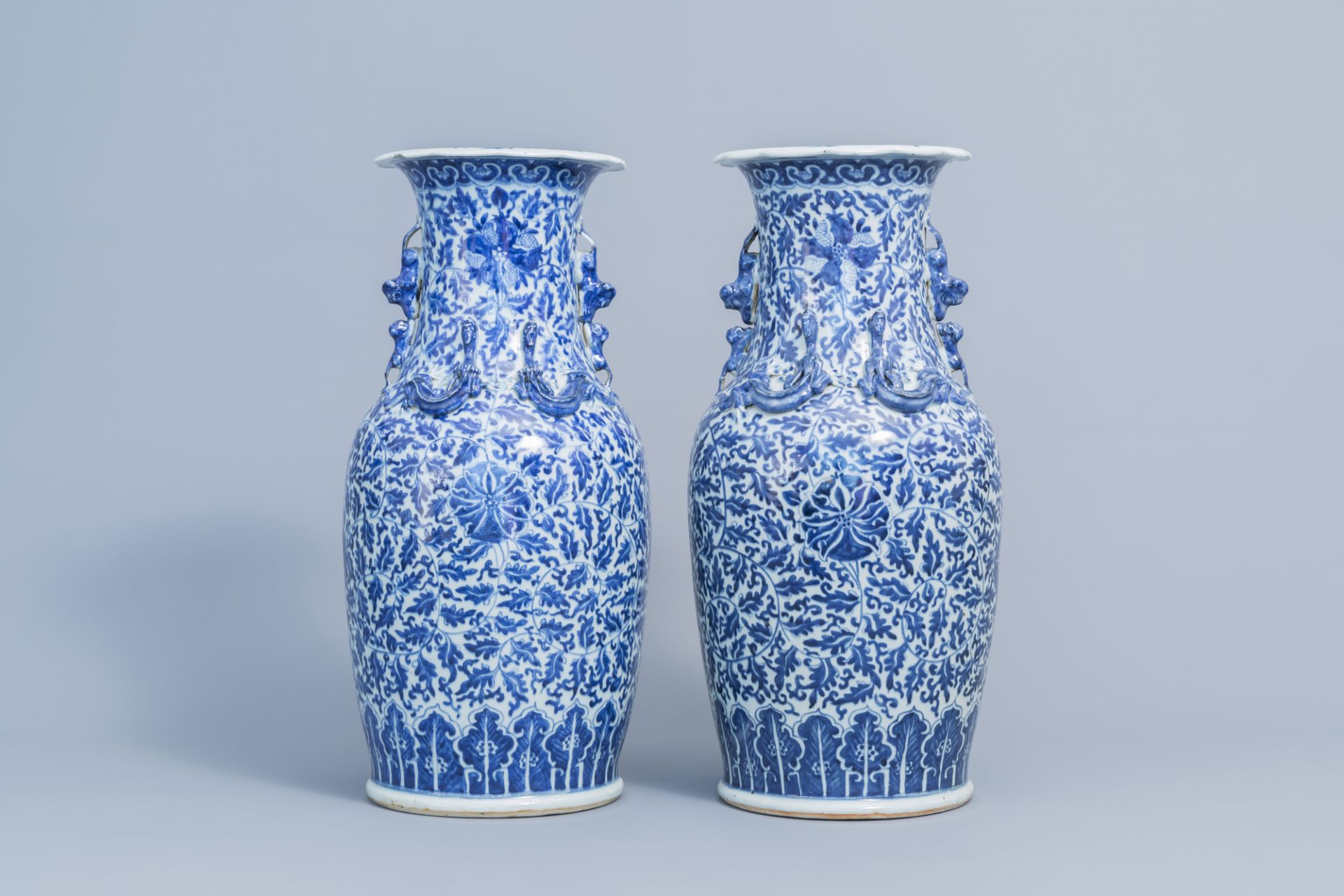 A pair of Chinese blue and white 'lotus scroll' vases with relief design, 19th C. - Image 3 of 6
