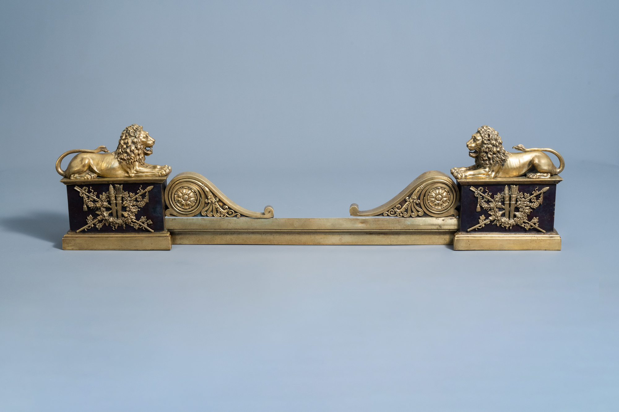 A pair of French Neoclassical patinated and gilt bronze andirons with a lion, 19th C.