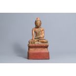 An inlaid partly gilt wood figure of a seated Buddha, Burma or Thailand, 19th/20th C.