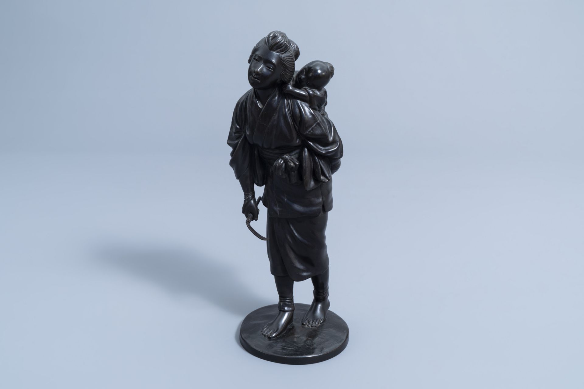 A Japanese bronze okimono of a mother and child on their way to the field, Meiji, 19th C.