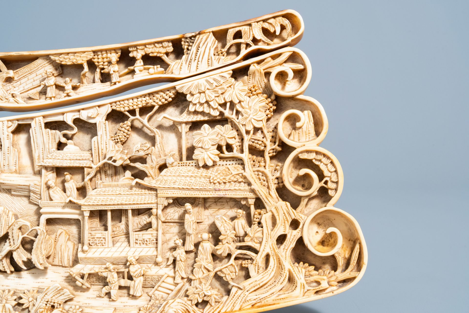 A Chinese richly carved ivory plaque with an animated city view on a wooden base, Canton, 19th C. - Image 13 of 15