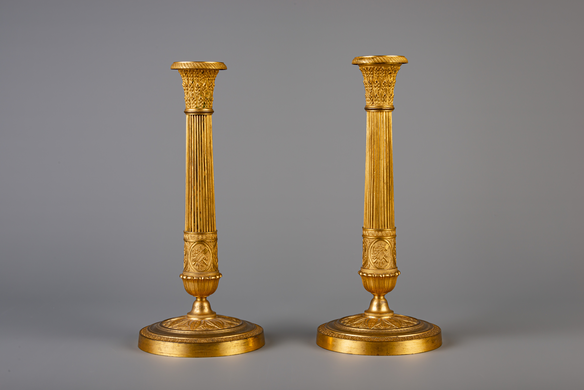 A pair of French Neoclassical gilt bronze candlesticks, 19th C.