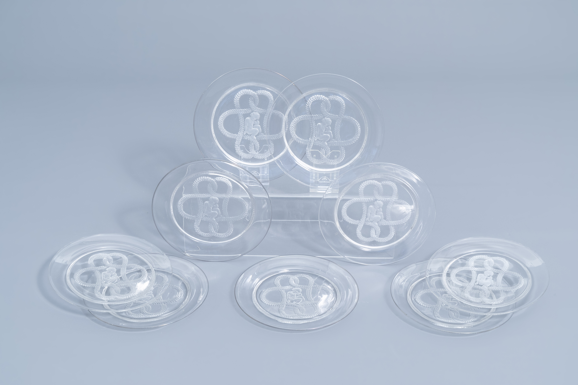 Nine French glass intaglio dishes with a putto surrounded by foliage, marked Lalique France, third q