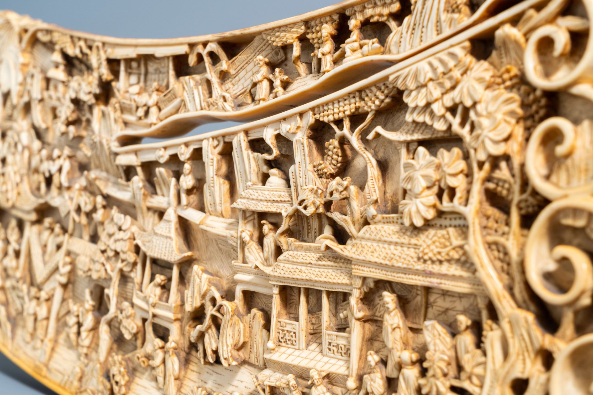 A Chinese richly carved ivory plaque with an animated city view on a wooden base, Canton, 19th C. - Image 14 of 15