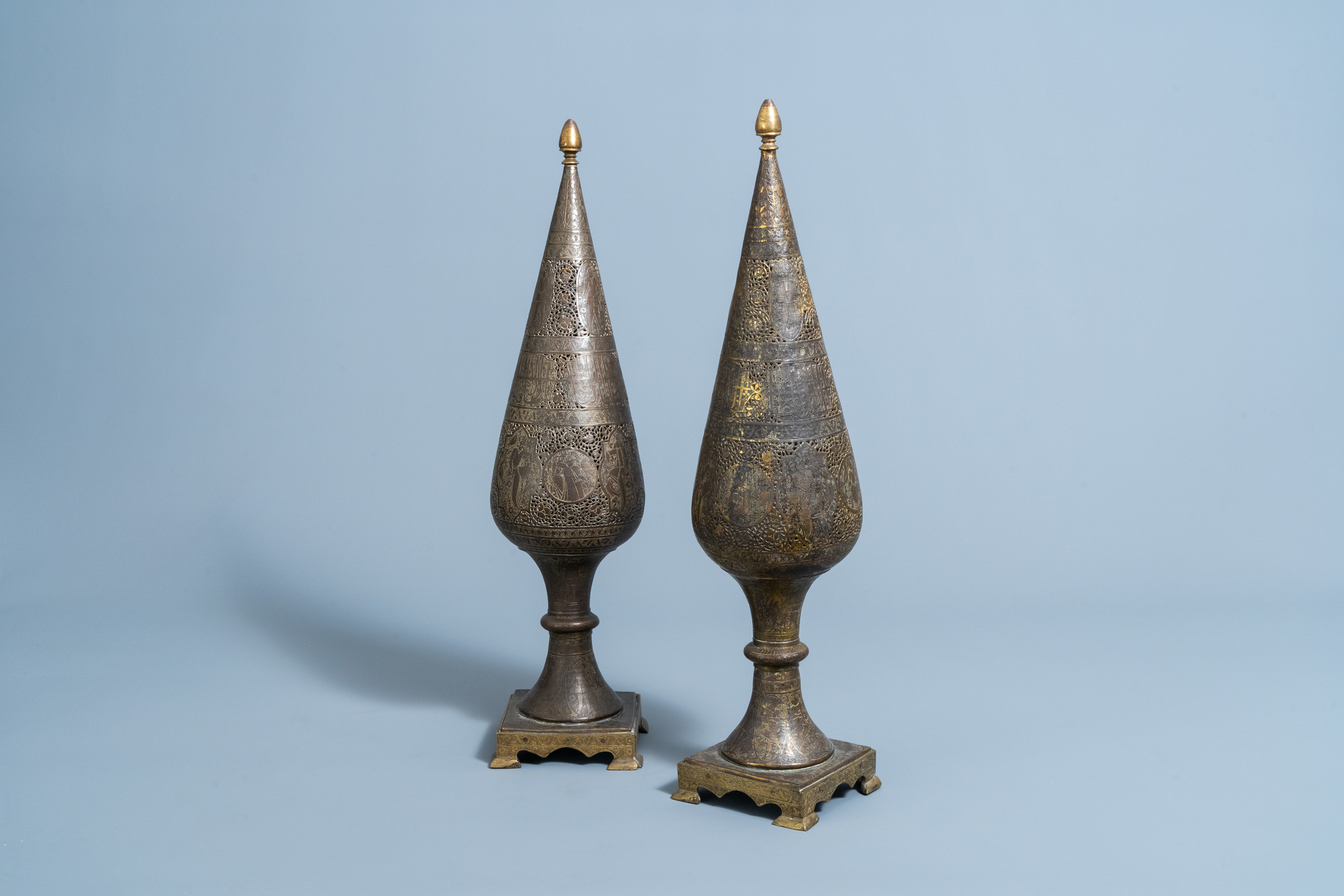A pair of reticulated gilt bronze cone shaped ornaments with figures and calligraphy, Qajar, Iran, 1