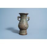 A Chinese archaic bronze vase with bird head handles, Qing