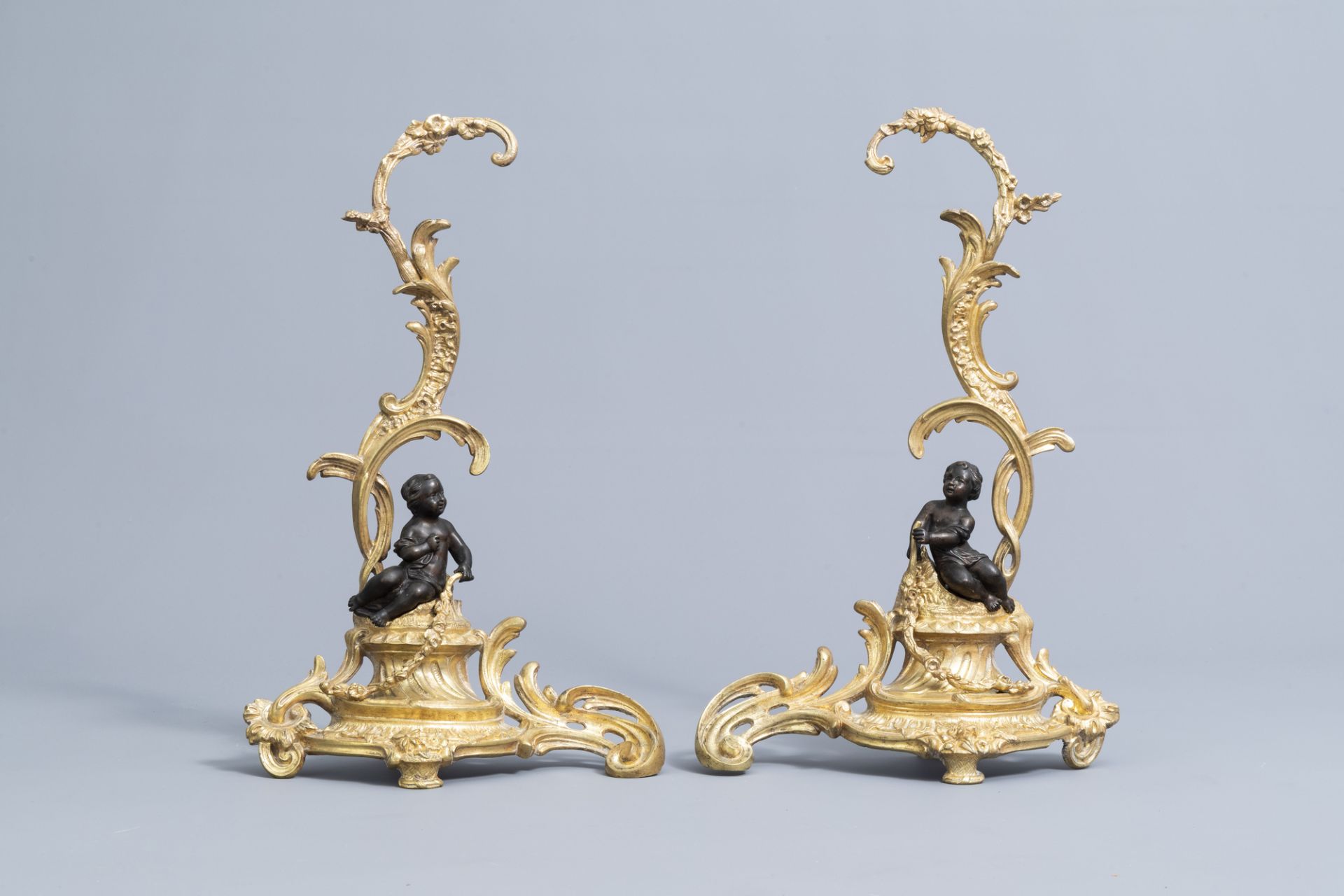 A pair of French Louis XV style patinated and gilt bronze andirons with putti, 19th C. - Image 2 of 15
