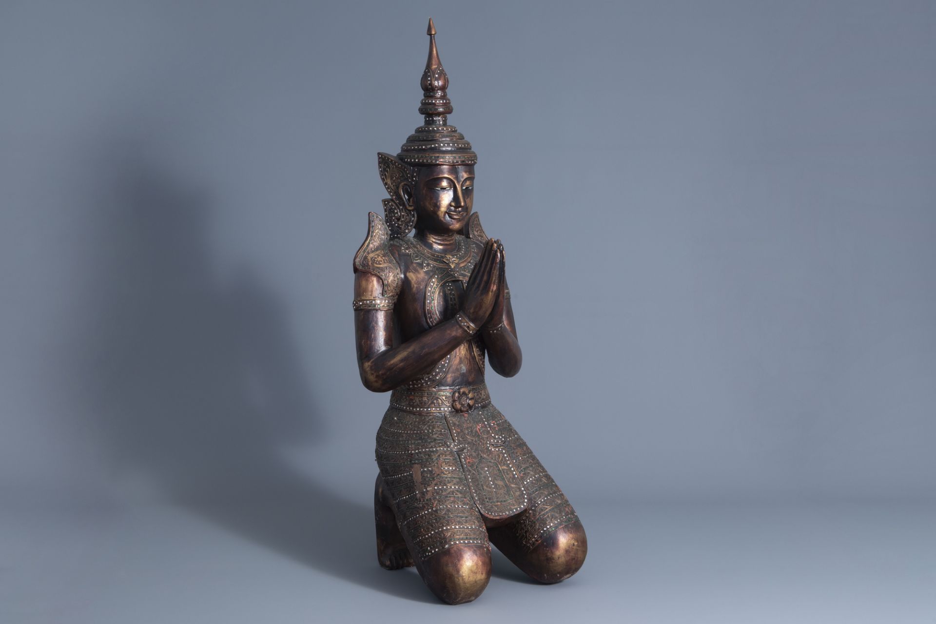 A patinated and gilt wooden kneeling Buddha figure, Thailand, 19th/20th C.