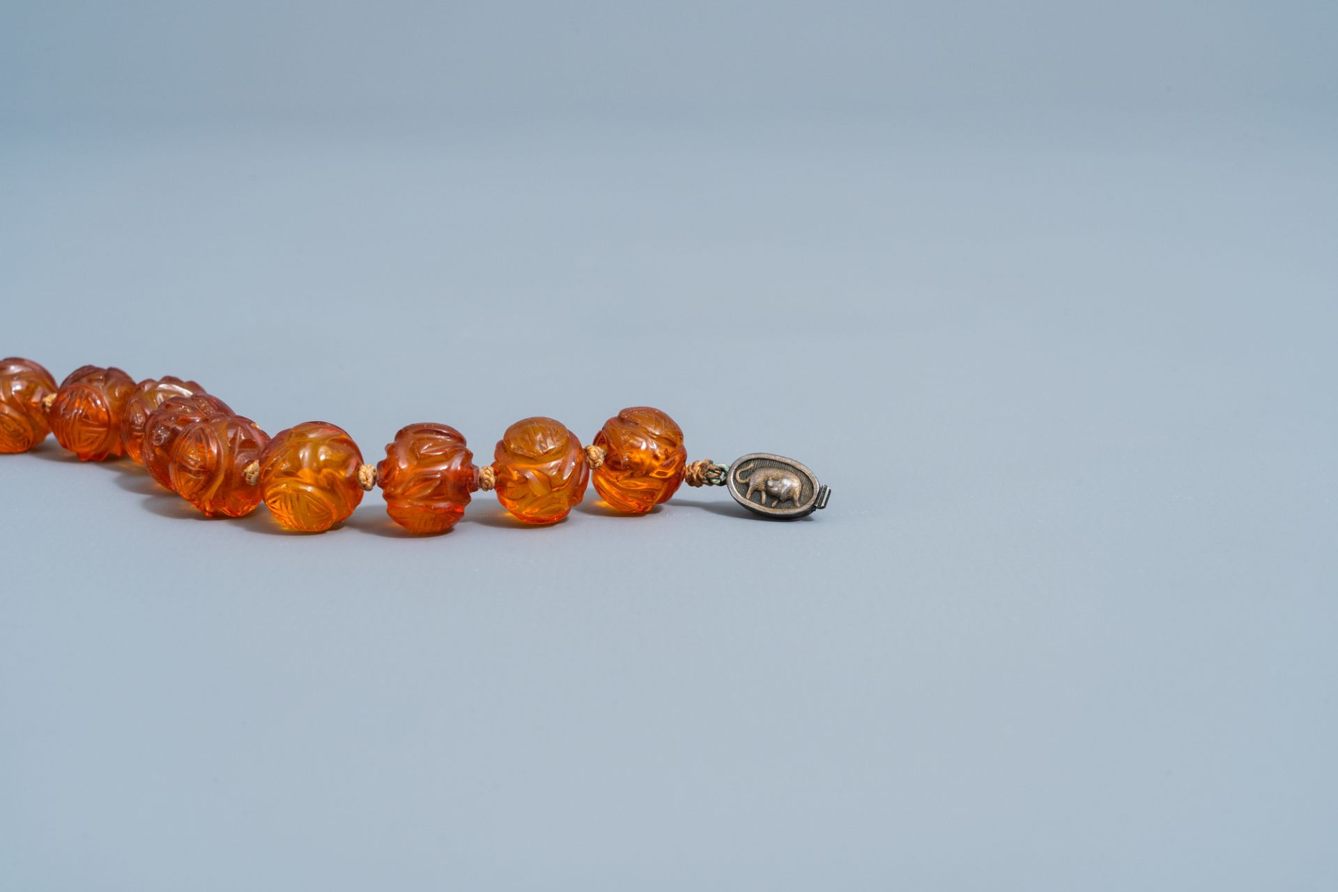 A Chinese necklace with translucent amber beads, 20th C. - Image 4 of 4