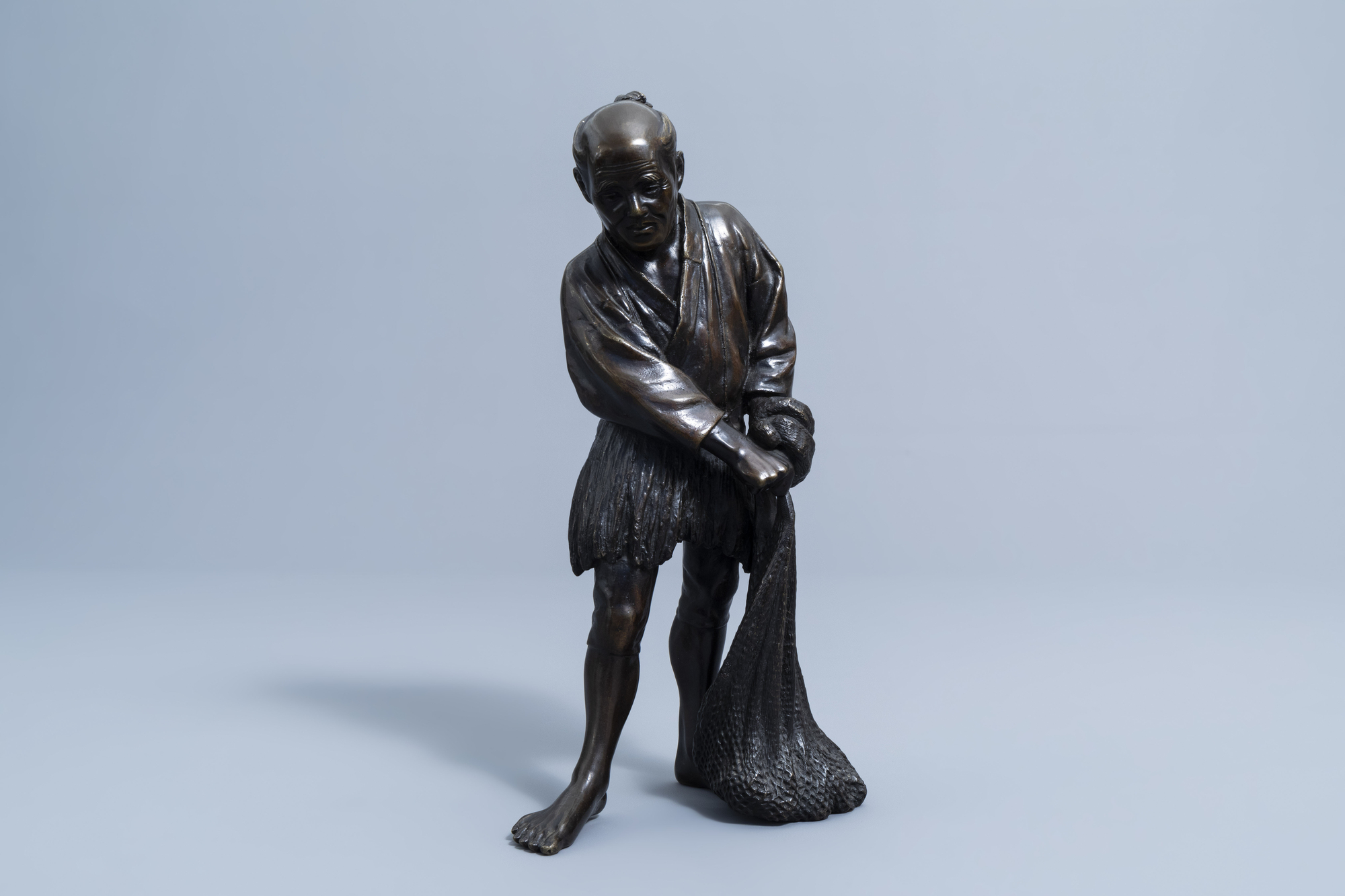 A Japanese bronze okimono of a fisherman, Meiji, 19th C. - Image 3 of 8