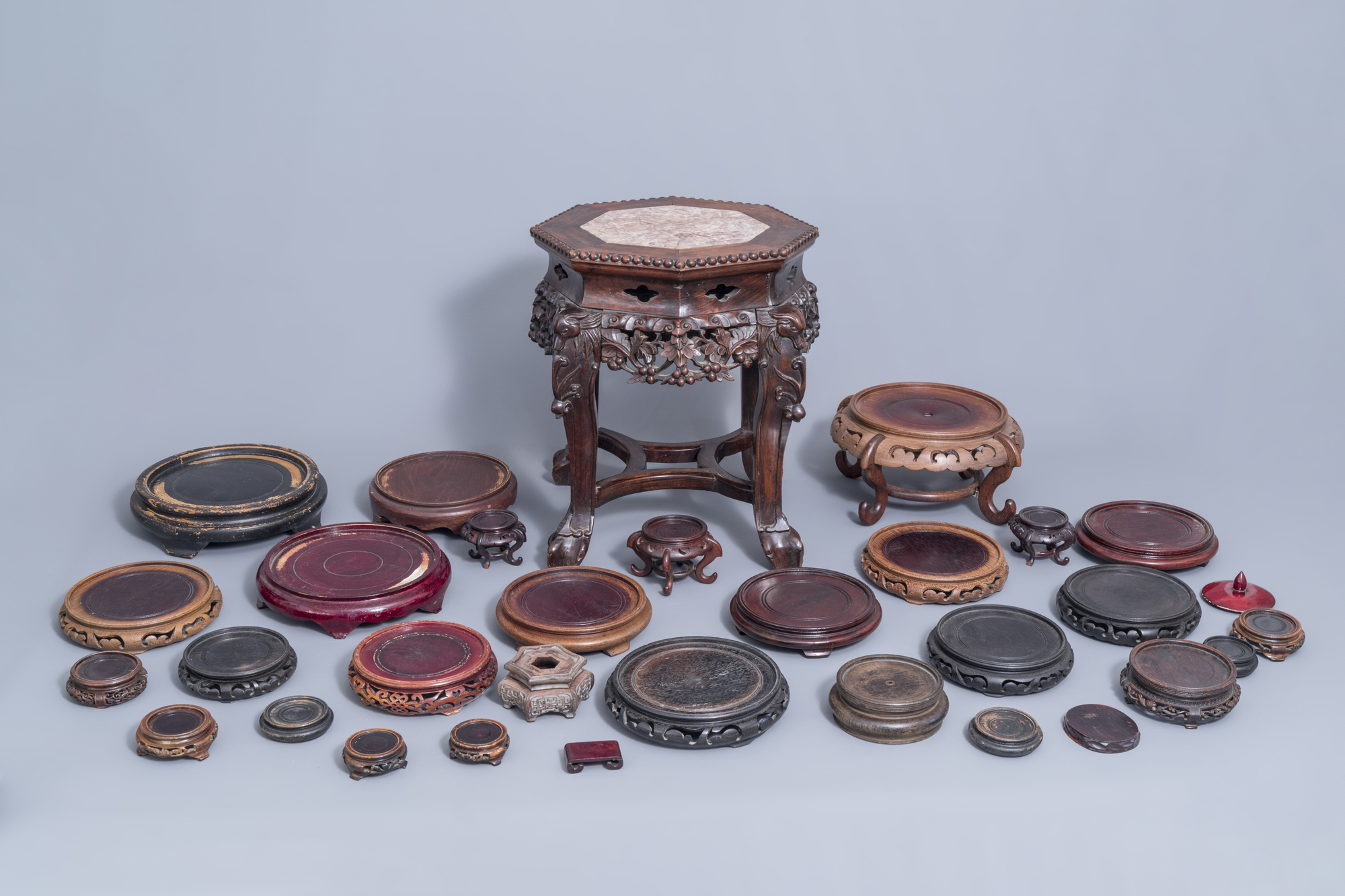 A collection of Chinese wooden stands and a carved wooden stand with marble top, 19th/20th C.