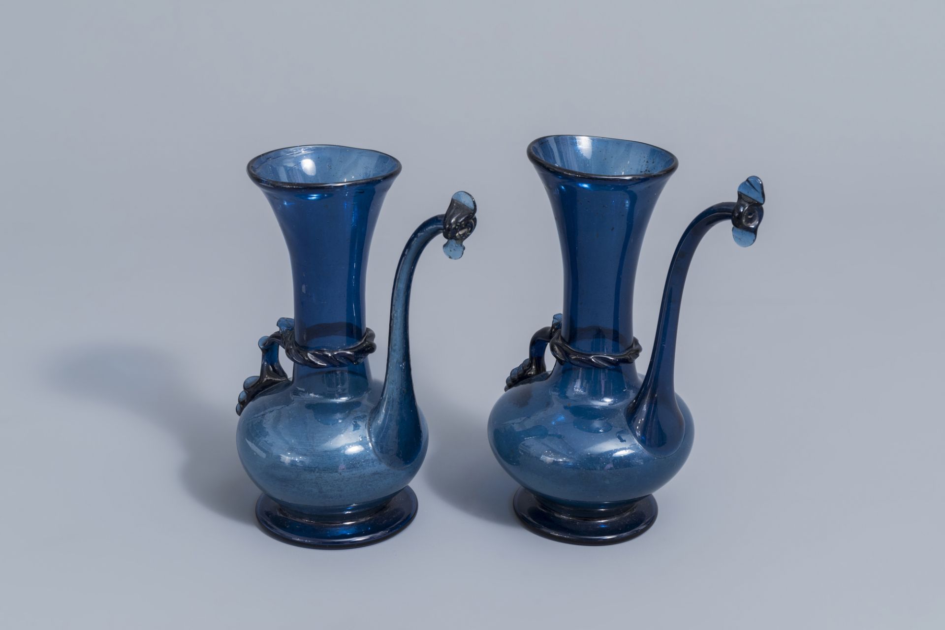 A pair of Islamic blue coloured relief decorated glass ewers or rosewater sprinklers, Qajar, Iran, 1