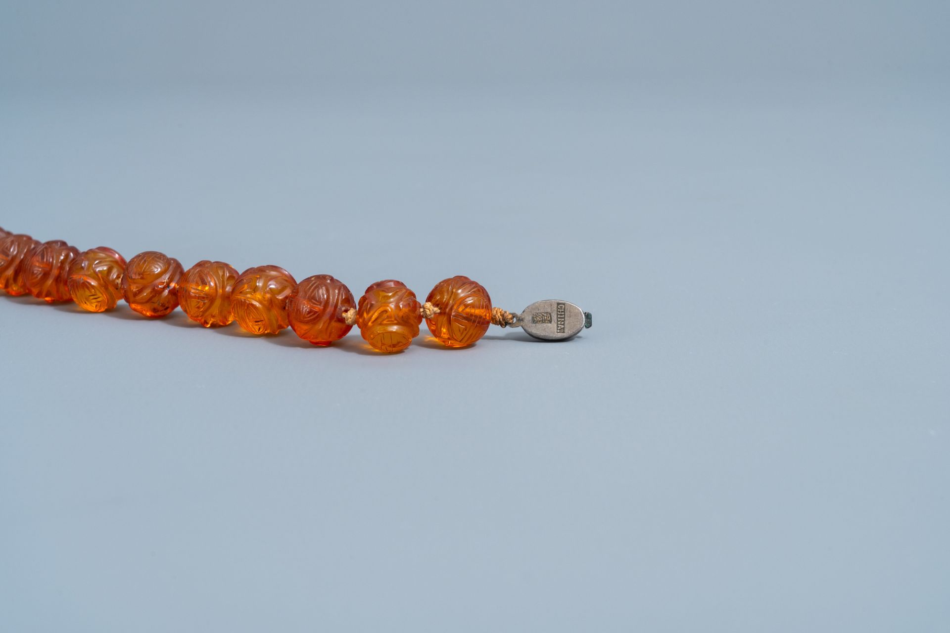 A Chinese necklace with translucent amber beads, 20th C. - Image 3 of 4