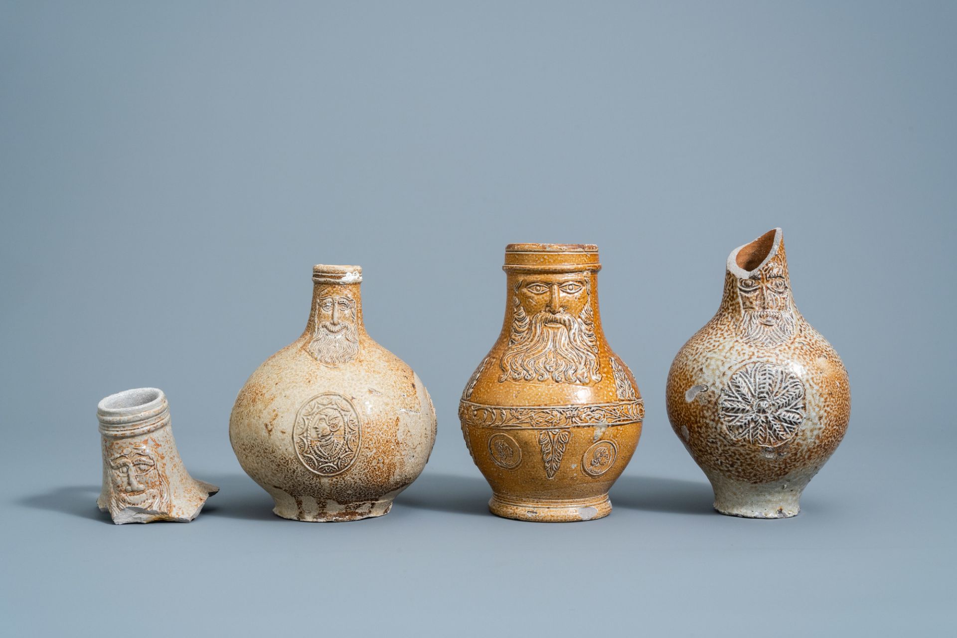 Three German stoneware bellarmine jugs and a neck fragment, 16th/17th C.