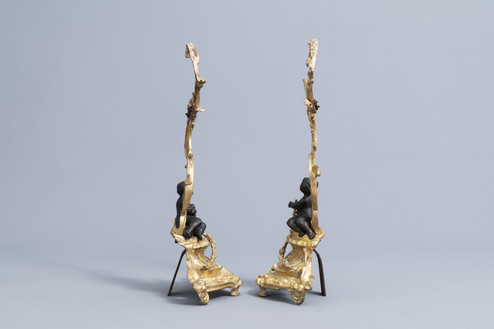 A pair of French Louis XV style patinated and gilt bronze andirons with putti, 19th C. - Image 5 of 15