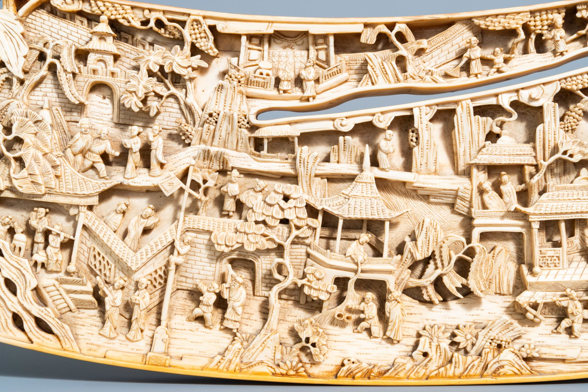 A Chinese richly carved ivory plaque with an animated city view on a wooden base, Canton, 19th C. - Image 11 of 15