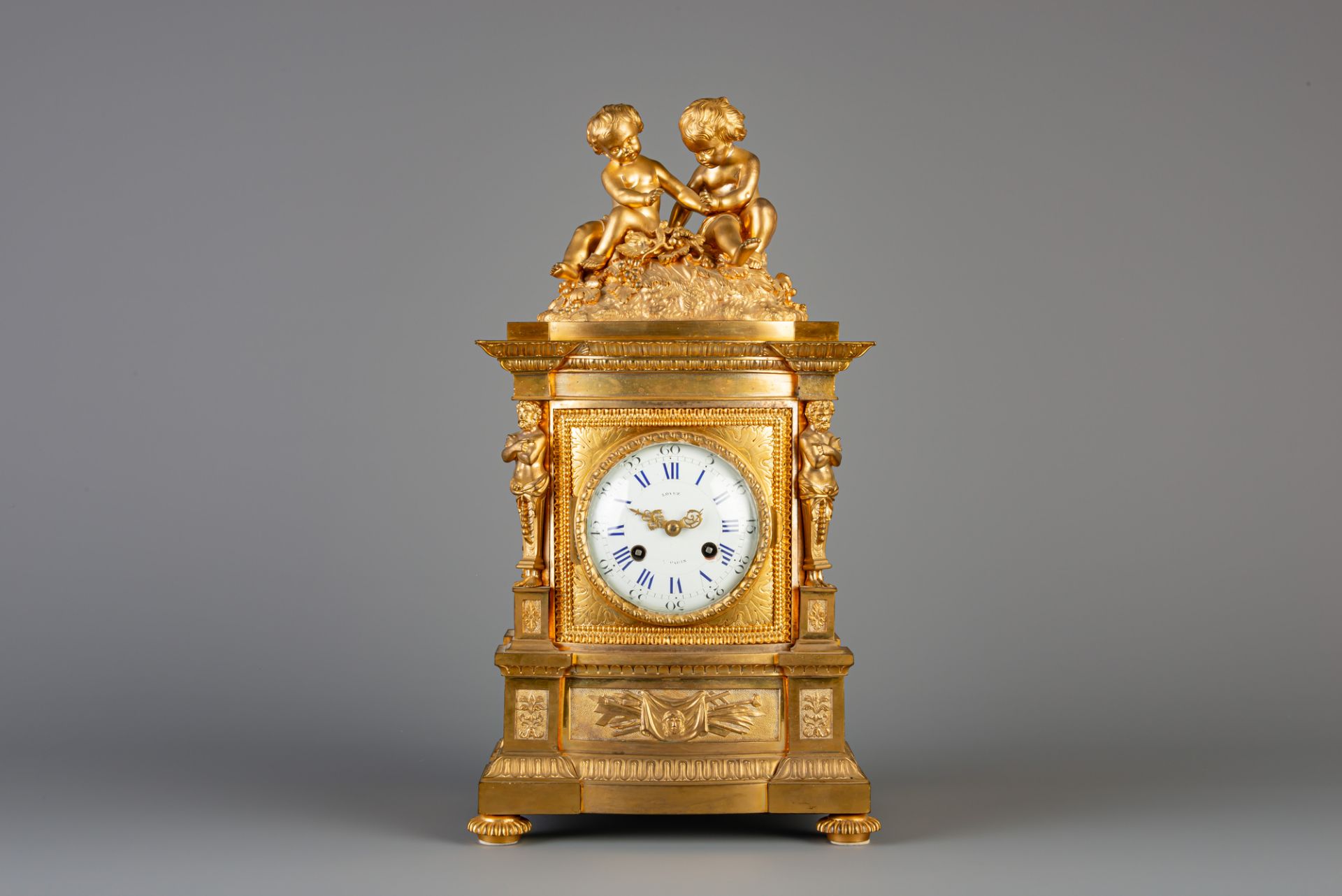 A gilt bronze mantel clock crowned with two putti and a lizard, France, 19th C.