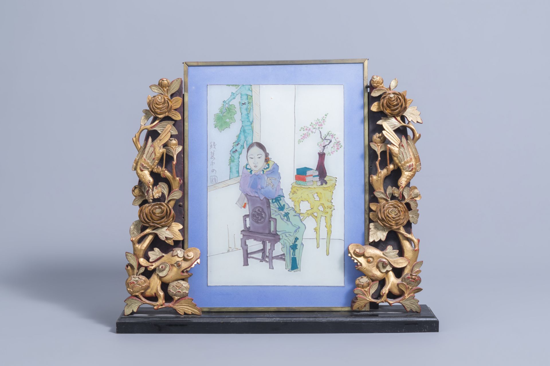 A Chinese painted glass window with a lady in an interior mounted in a wooden table screen, 19th/20t