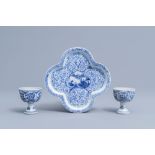 A pair of Chinese blue and white stem cups with floral design and a four-lobed teapot stand, Kangxi