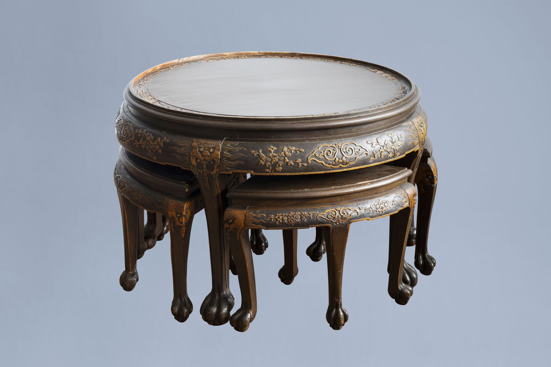 A Chinese wooden coffee table and four stools with relief design, 20th C.