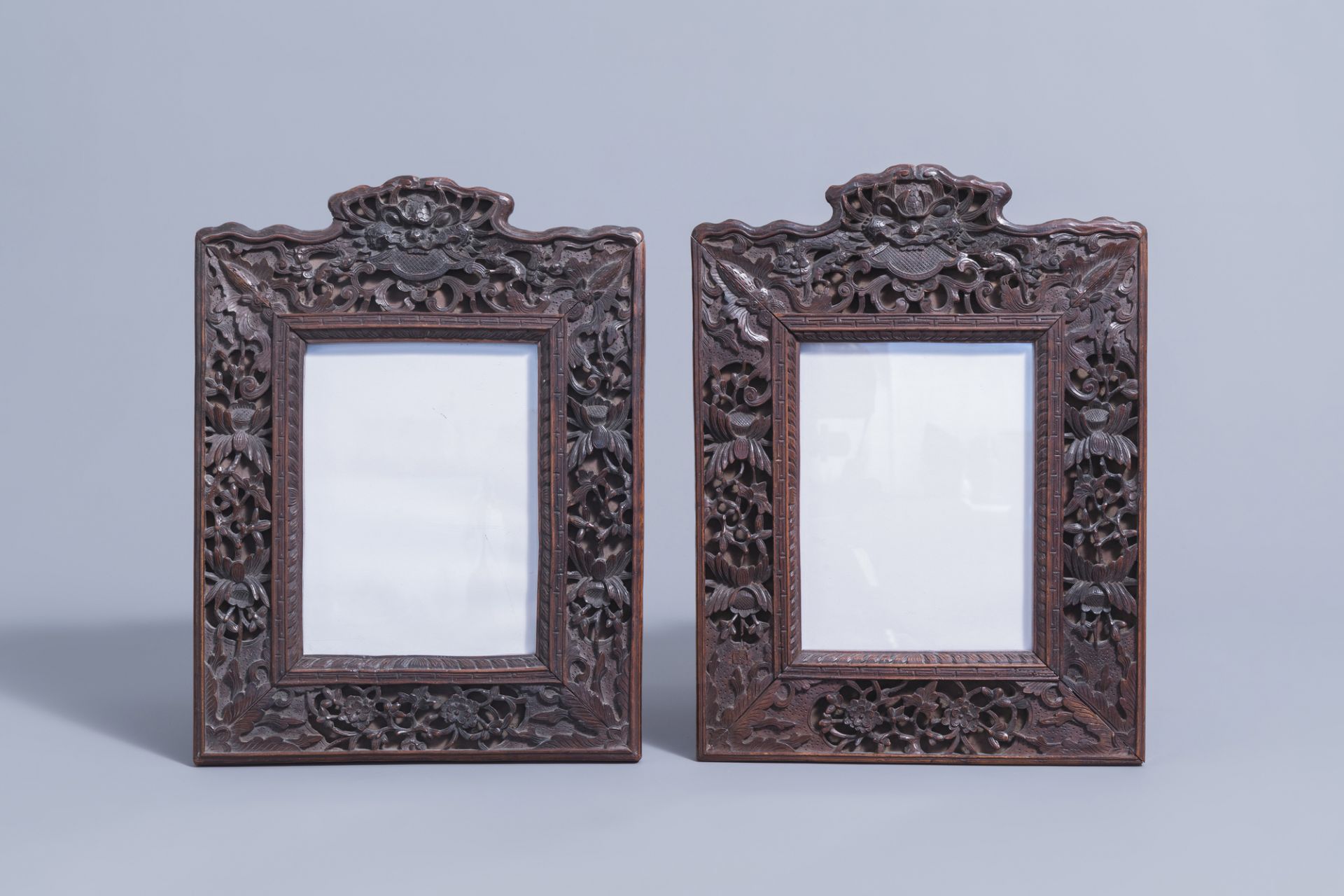 A pair of Chinese carved wooden frames with animals and flowers, 19th C.