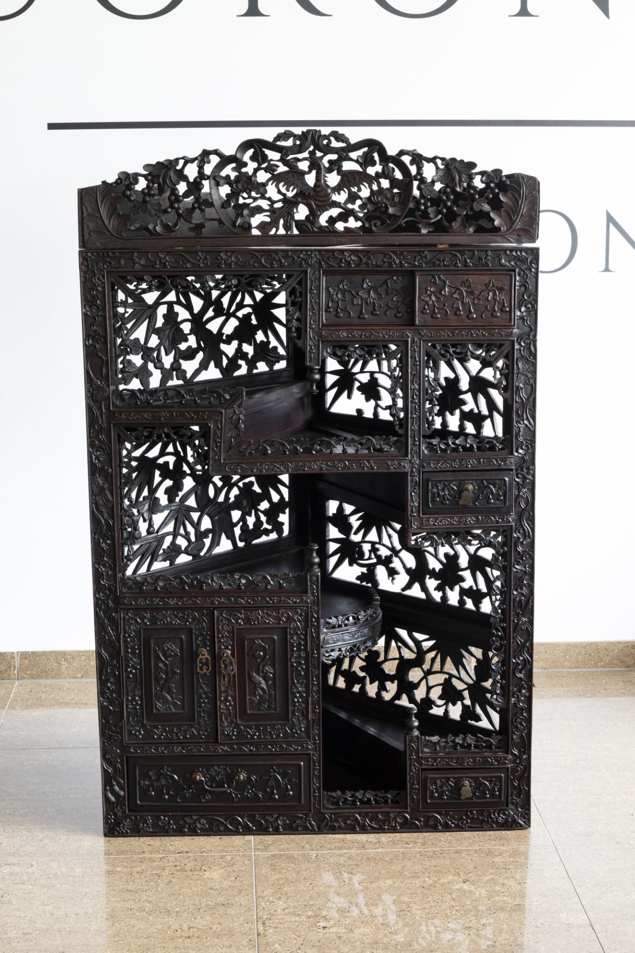 A Chinese carved wooden open worked corner display cabinet with floral design, 19th/20th C. - Image 2 of 7