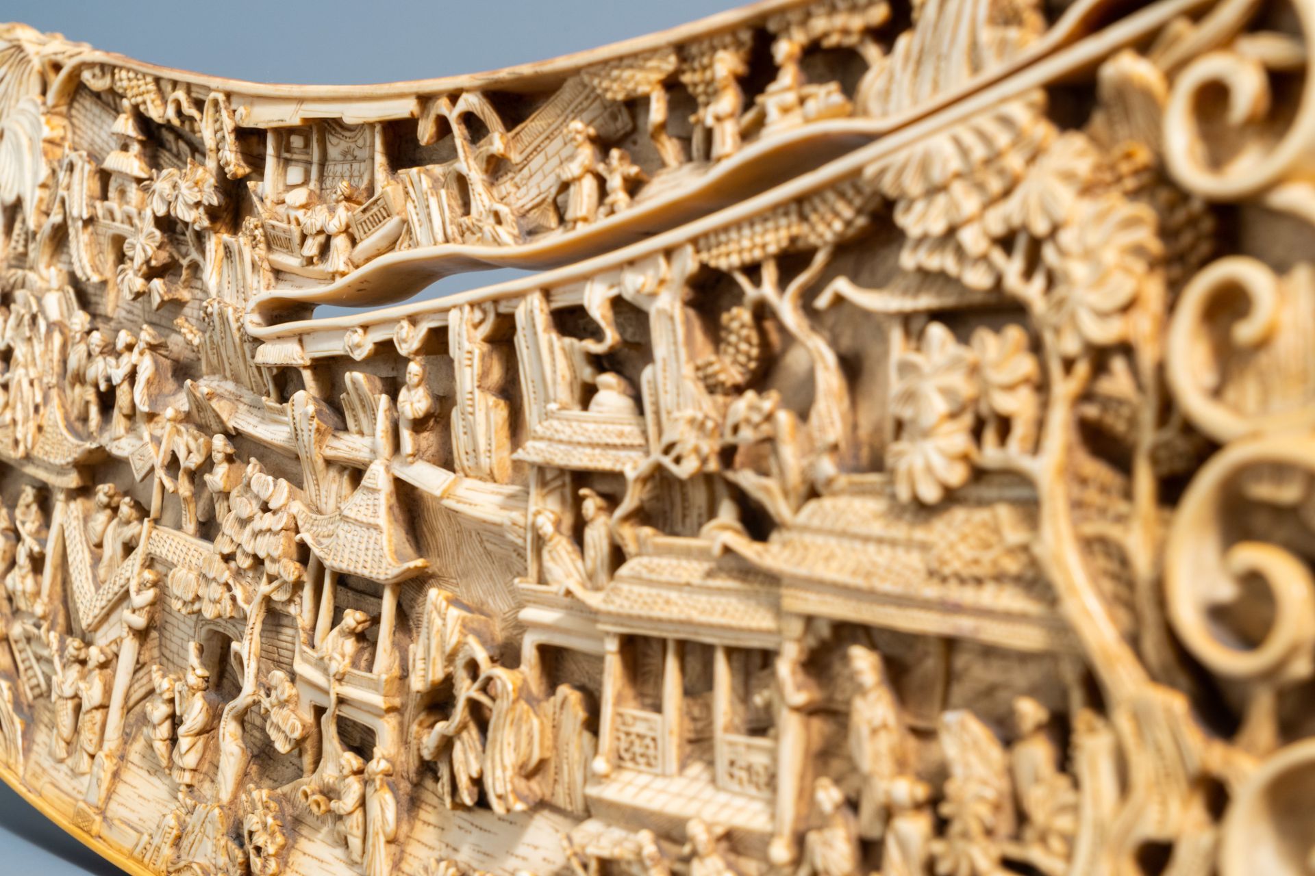 A Chinese richly carved ivory plaque with an animated city view on a wooden base, Canton, 19th C. - Image 15 of 15