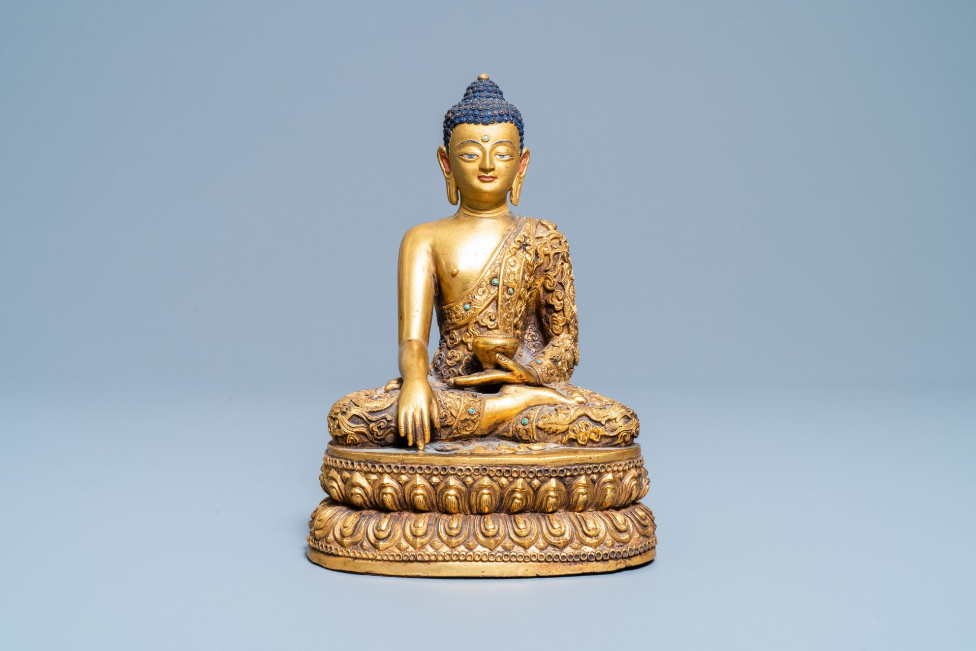 A Chinese turquoise inlaid gilt bronze figure of Buddha with an inscription, 20th C.