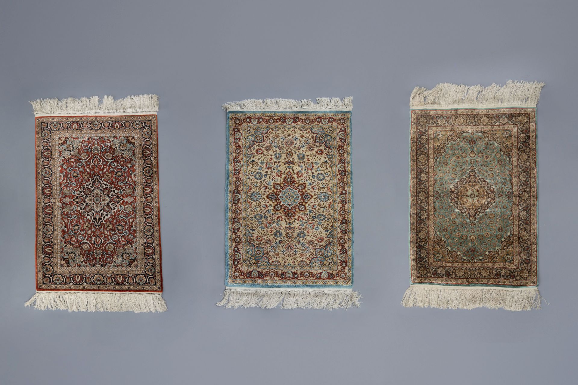 Three Oriental rugs with floral design and a central medallion, silk on cotton, 20th C.