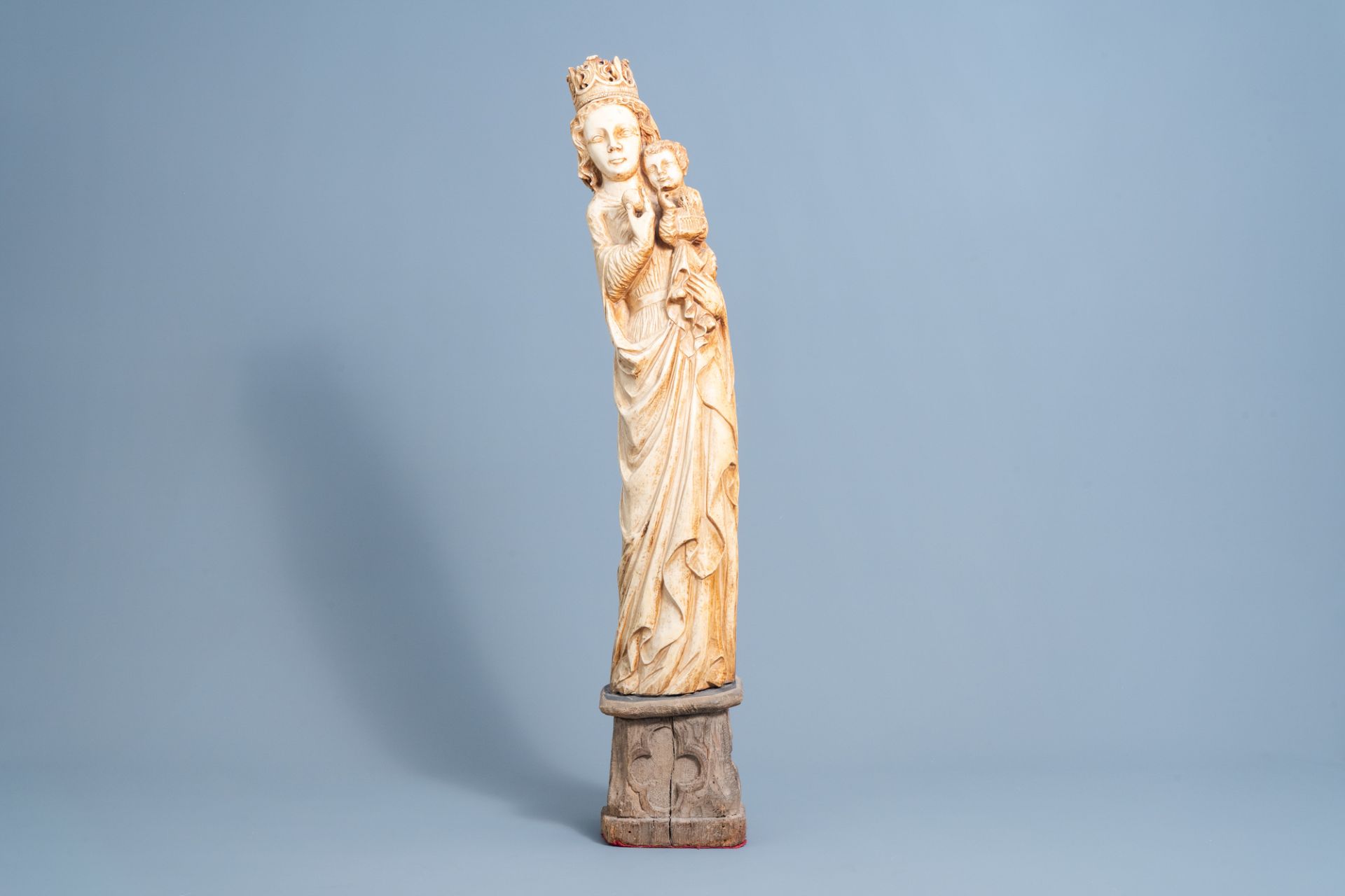 A French Gothic revival carved ivory group of Madonna and Child on an oak wooden base, probably atel