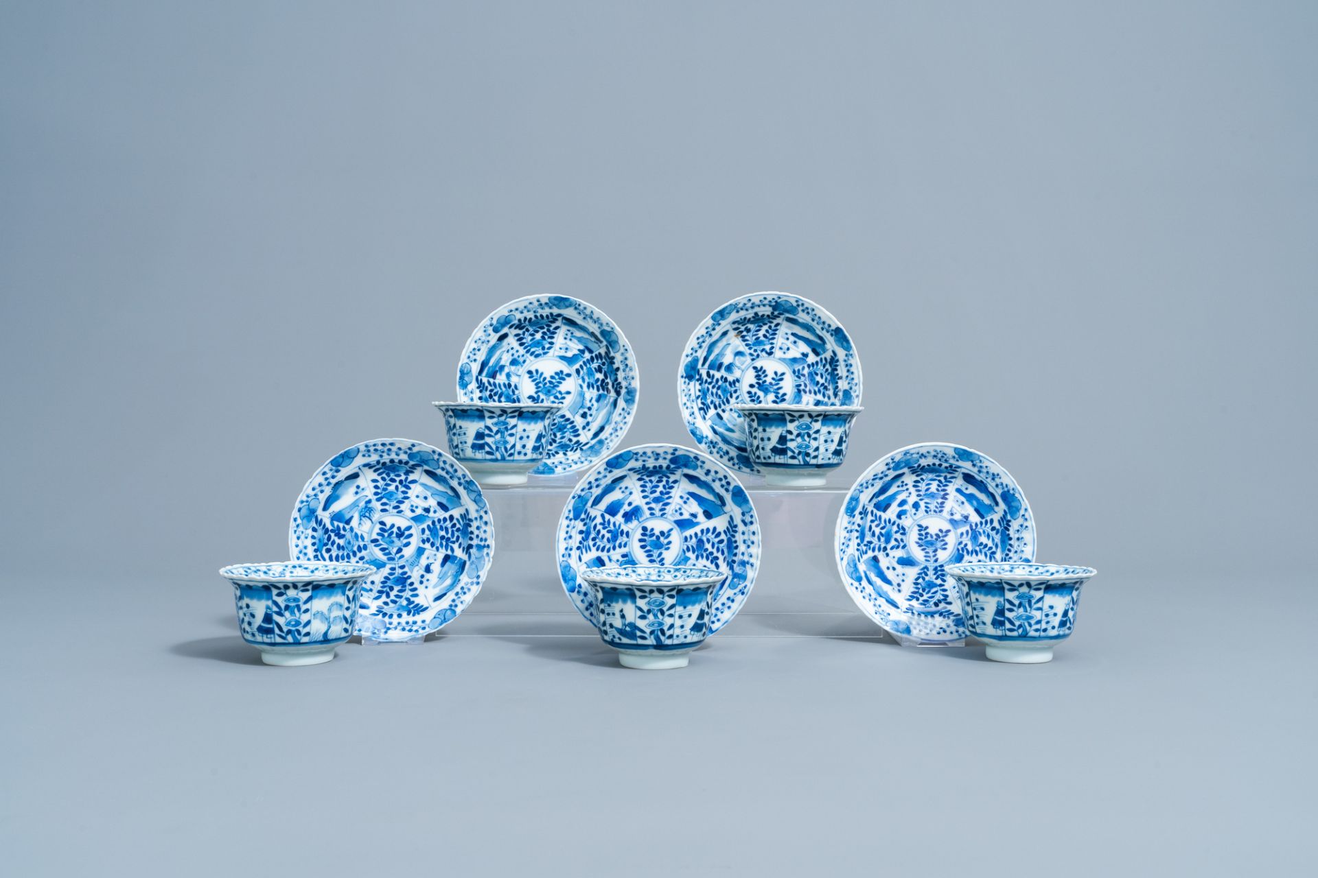 Five Chinese blue and white cups and saucers with landscapes and floral design, Kangxi mark, 19th C.