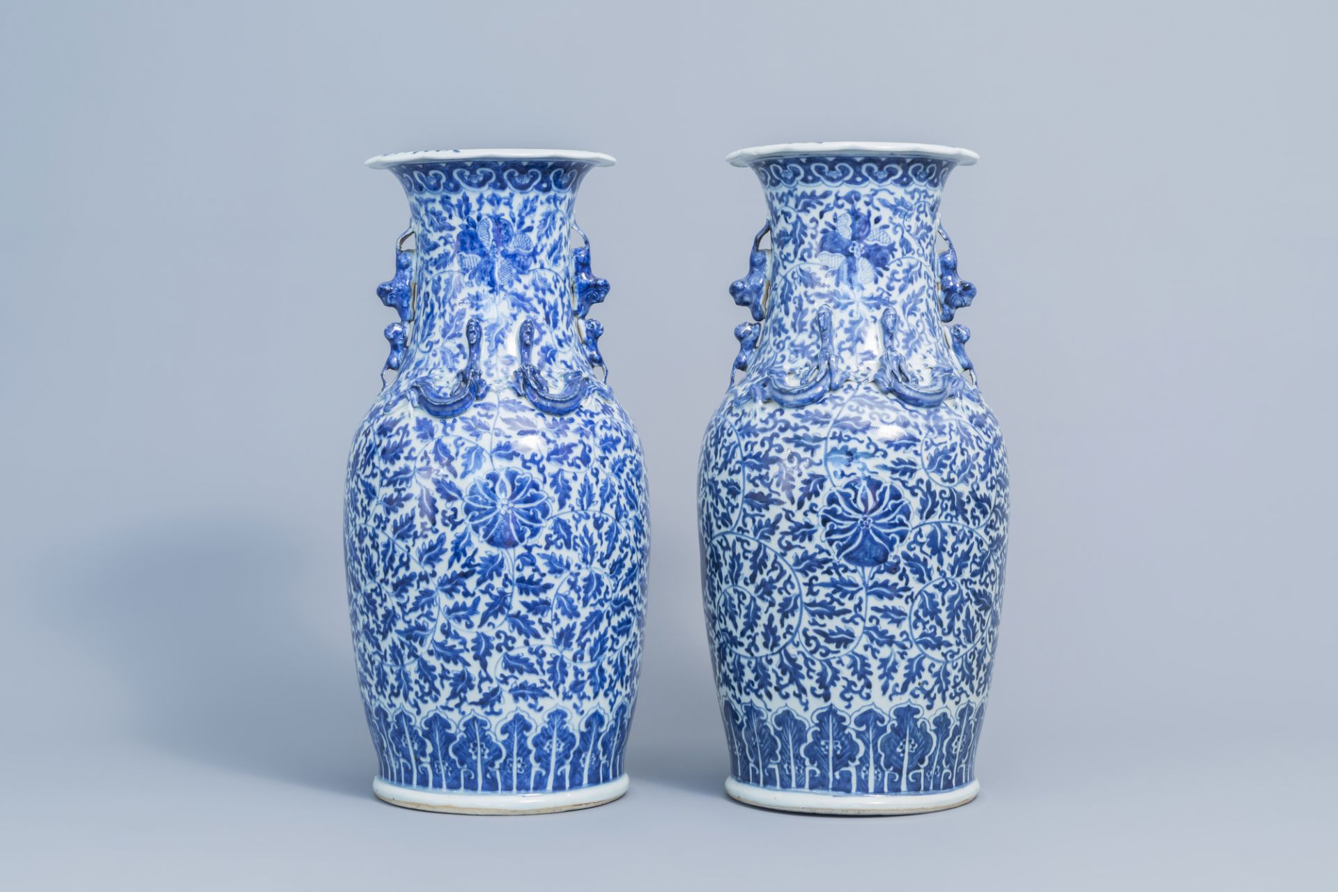 A pair of Chinese blue and white 'lotus scroll' vases with relief design, 19th C.