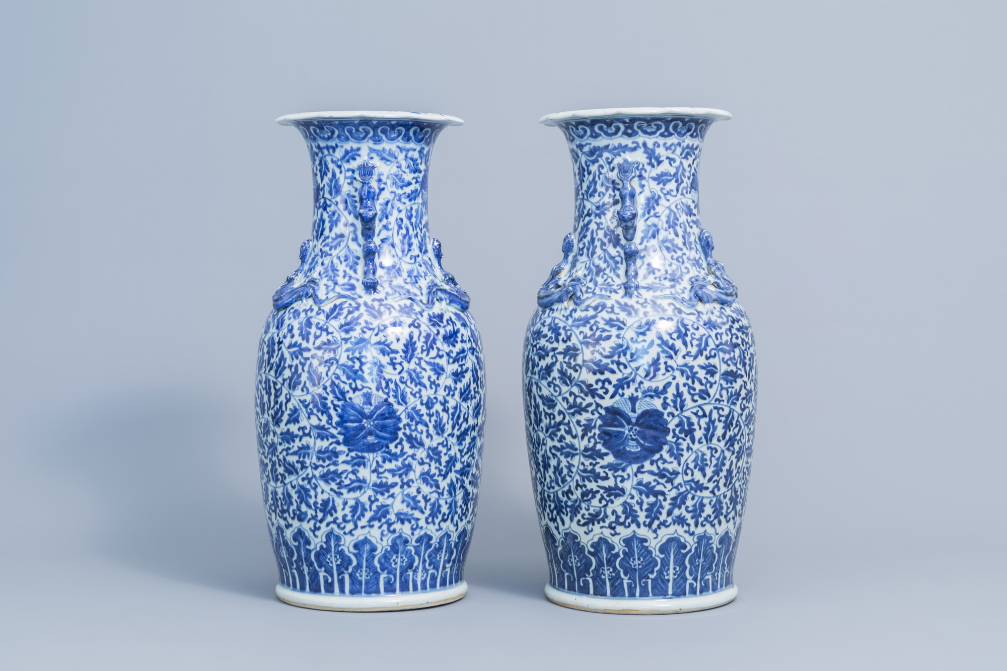 A pair of Chinese blue and white 'lotus scroll' vases with relief design, 19th C. - Image 2 of 6