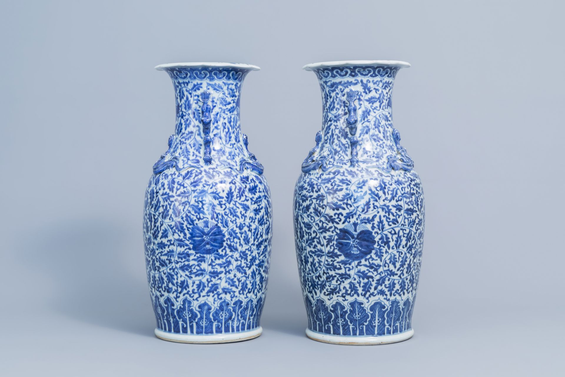 A pair of Chinese blue and white 'lotus scroll' vases with relief design, 19th C. - Image 2 of 6