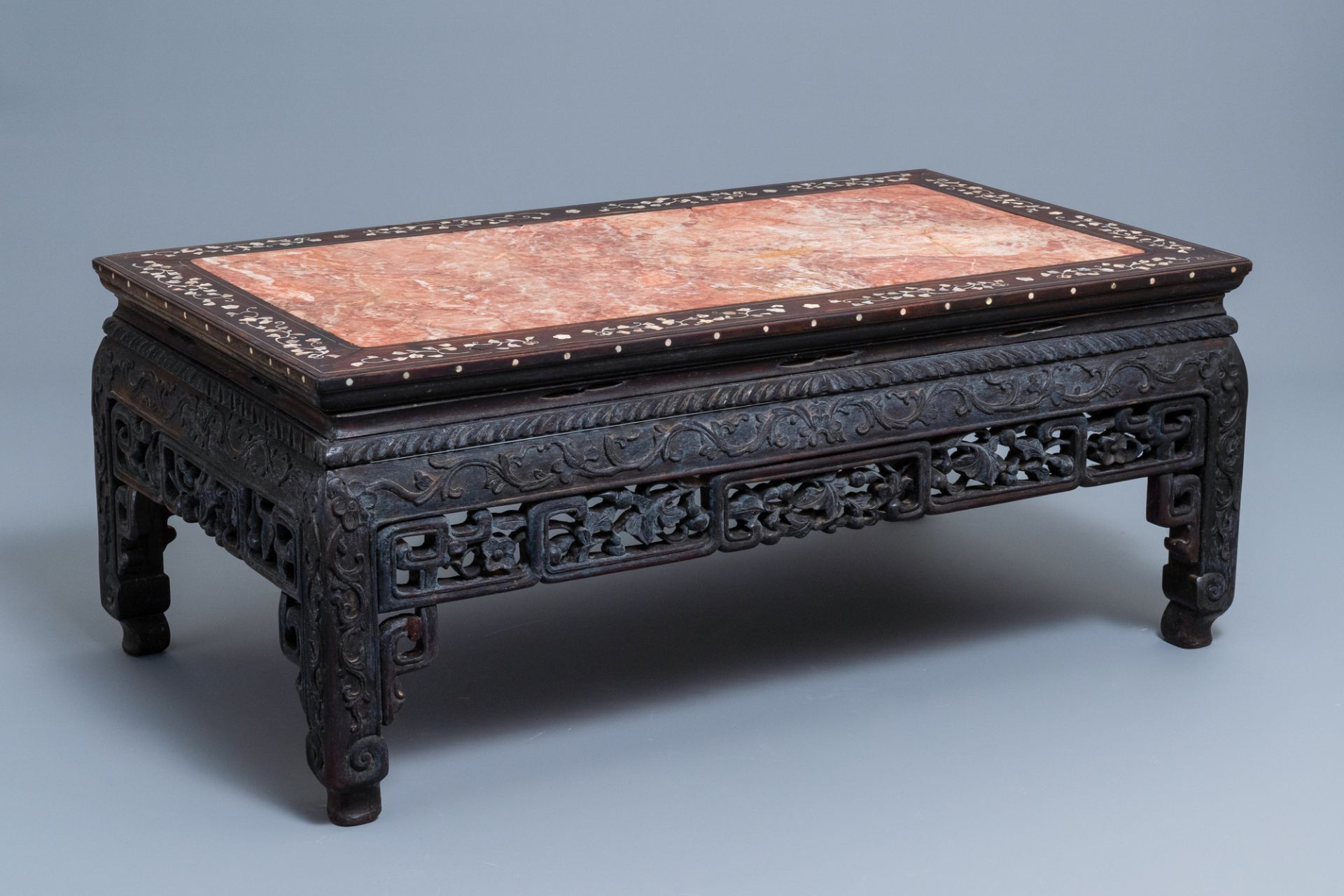 A Chinese mother-of-pearl inlaid wooden low side table with marble top, 19th C.