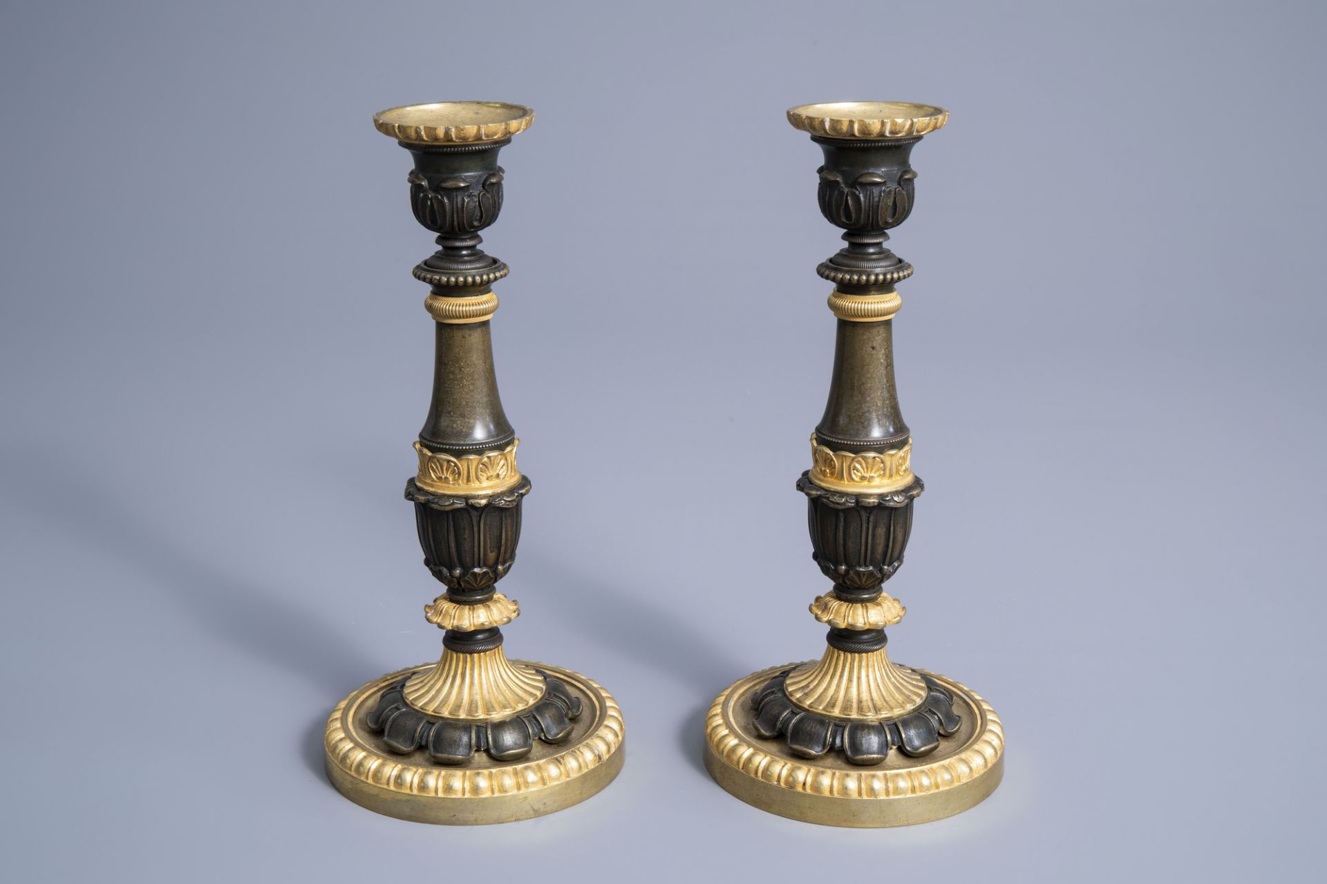 A pair of French gilt and patinated bronze candlesticks with acanthus leaves, 19th C.