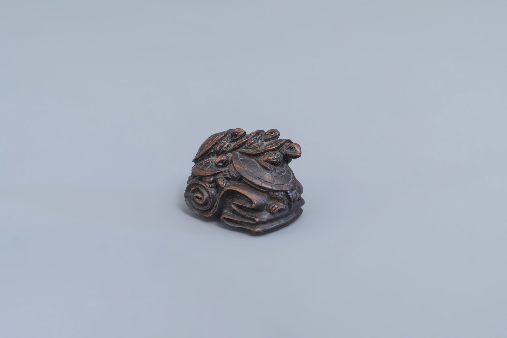 A Japanese wooden 'turtles' netsuke, signed, 20th C.