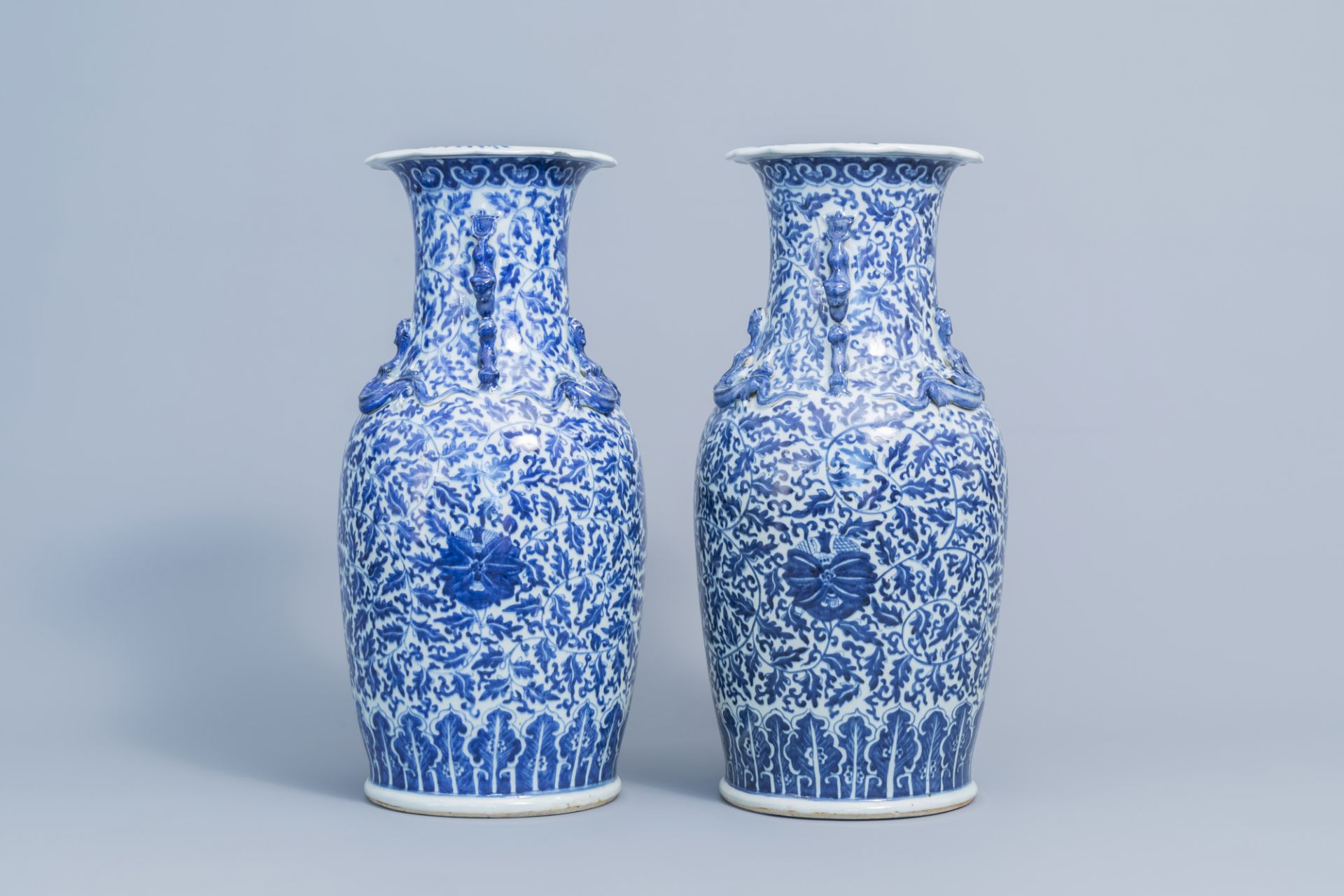 A pair of Chinese blue and white 'lotus scroll' vases with relief design, 19th C. - Image 4 of 6