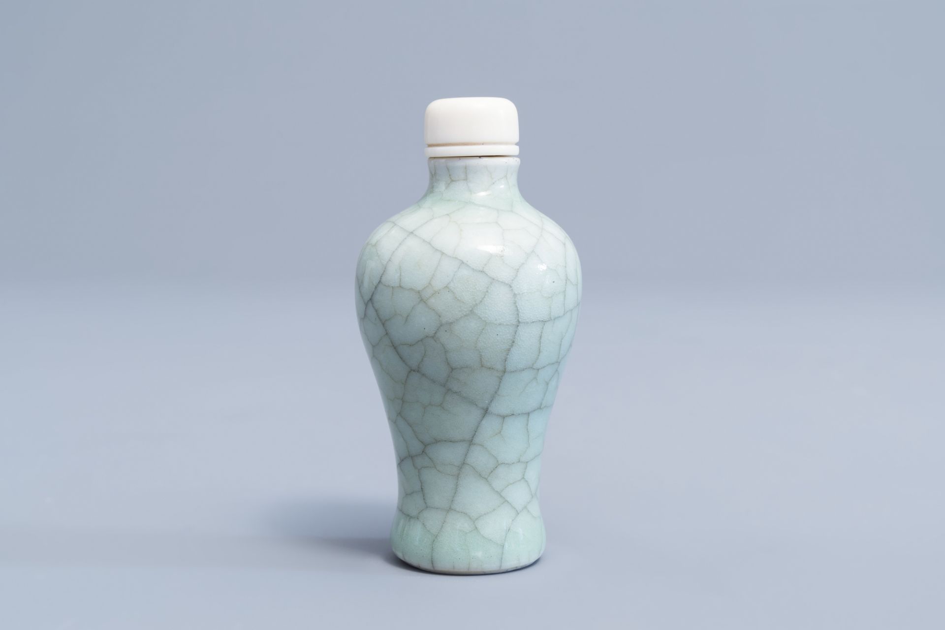 A Chinese celadon crackled glazed snuff bottle with ivory stopper, 19th/20th C.