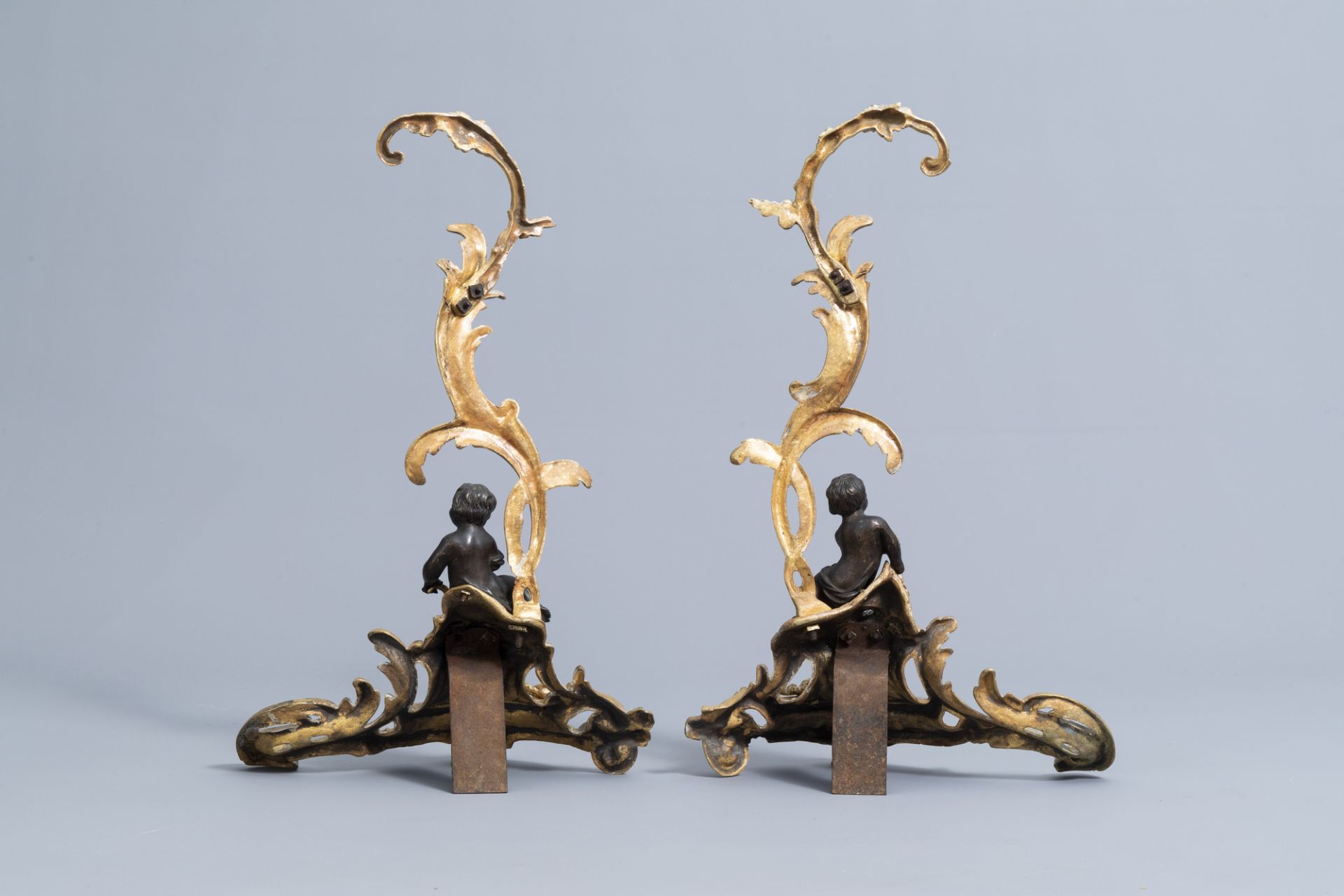 A pair of French Louis XV style patinated and gilt bronze andirons with putti, 19th C. - Image 3 of 15