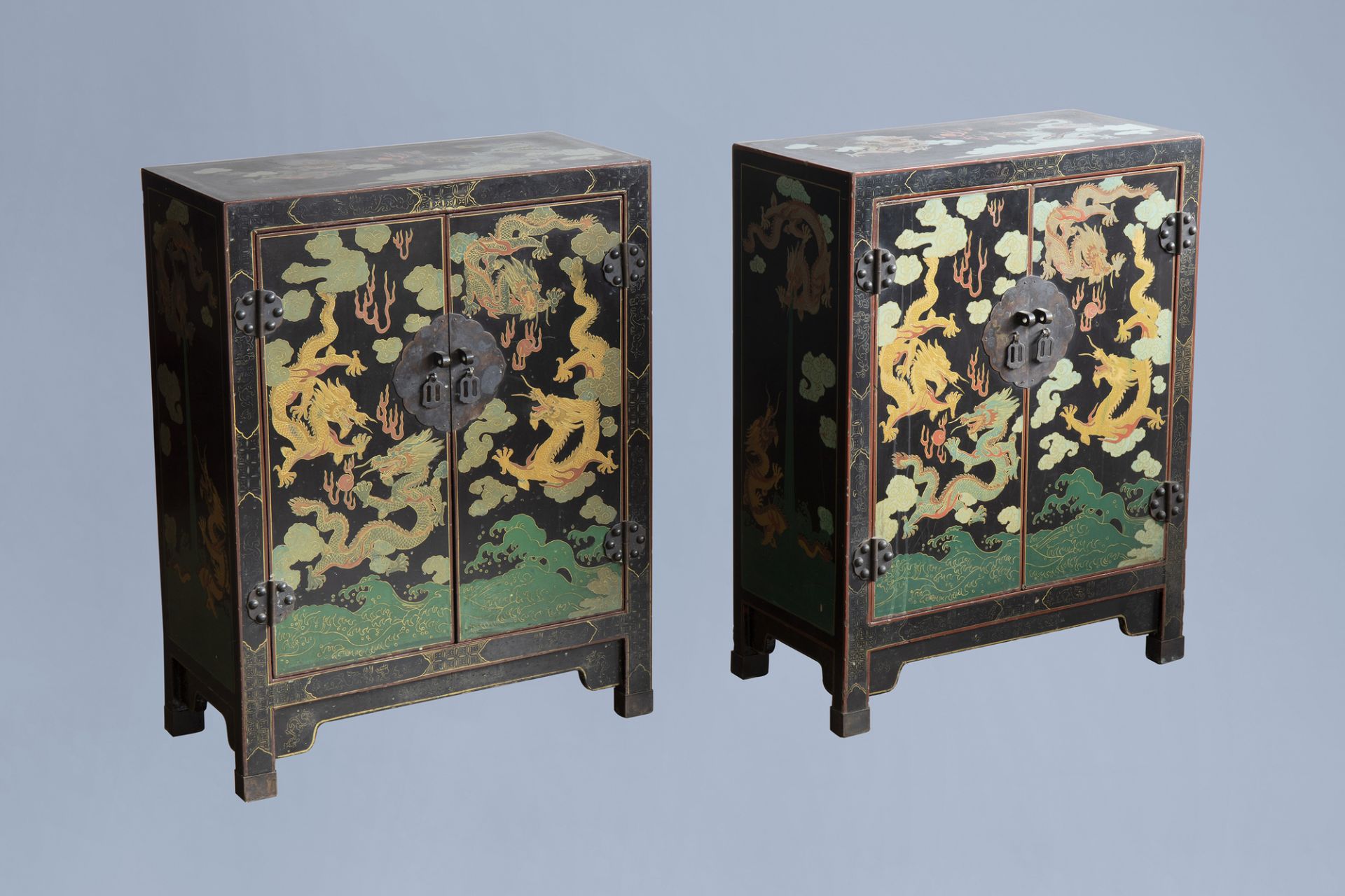 A pair of Chinese black lacquered wooden 'dragons chasing the pearl' two-door cabinets, 20th C.