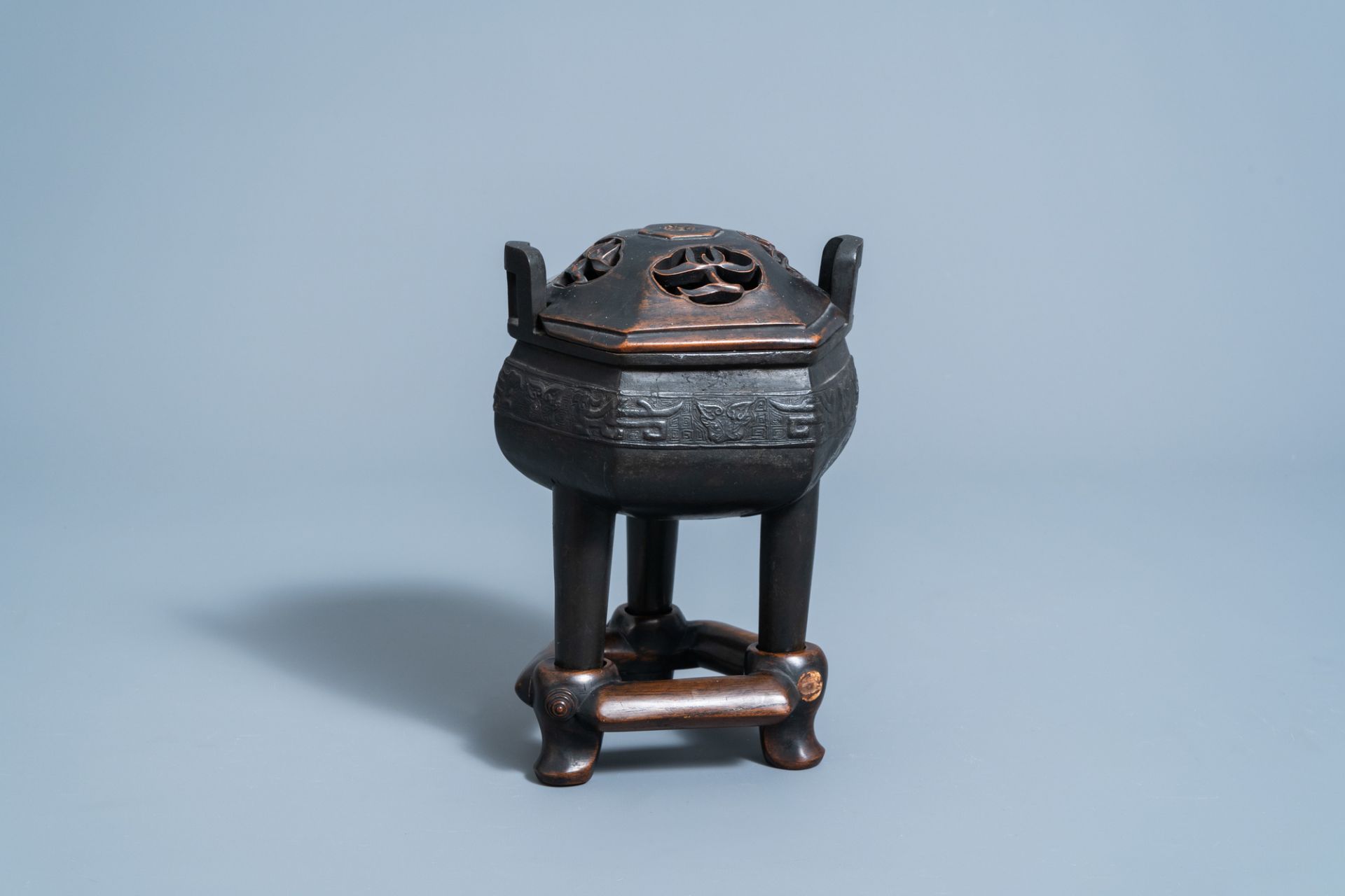 A Chinese bronze tripod censer with wooden cover and stand, Ming