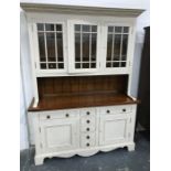 Modern dresser, cream painted with three glazed doors enclosing shelves, above sideboard of seven