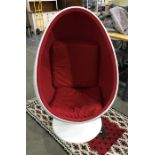 In the manner of Eero Aarnio egg pod chair with white plastic outer and red fabric inner