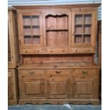 20th century pine dresser, the moulded cornice above two glazed doors, open shelves and three