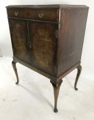 20th century mahogany cabinet with single drawer above two cupboard doors, on cabriole supports,